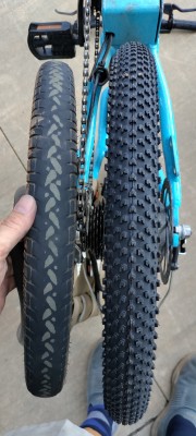 picture of two bike tires side by side, one is very worn down, the other is brand new