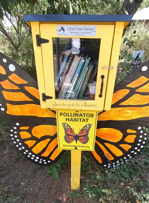 picture of a Little Free Library with a sign that says "Pollinator Habitat"